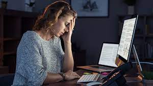 A woman in stress working on laptop