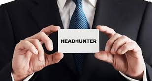 A man holding up a business card that says headhunter.